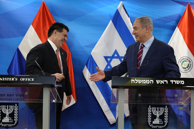 Israeli Prime Minister Benjamin Netanyahu (right) reaching out to shake hands with Paraguayan President Horacio Cartes as they meet at his Jerusalem office on July 19, 2016 (AFP photo)