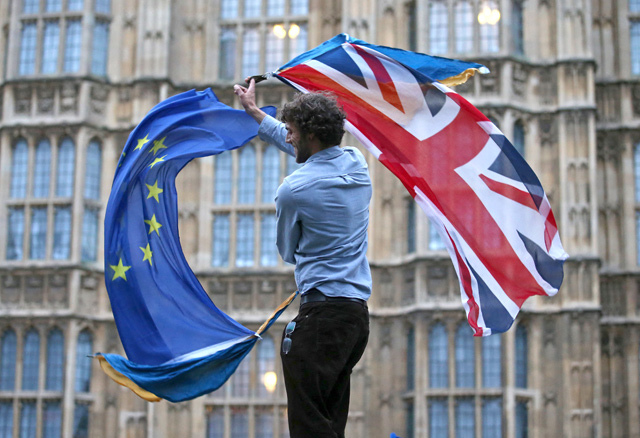 In this file photo taken on June 28, 2016, a man waves both a union flag and a European flag together on College Green outside The Houses of Parliament at an anti-Brexit protest in central London, on June 28, 2016 (AFP photo)