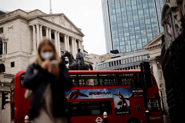 A pedestrian and a London bus on Thursday go past the Bank of England which hiked its key interest rate from 0.10 per cent to 0.25 per cent, as it seeks to combat decade-high inflation despite Omicron concerns (AFP photo)