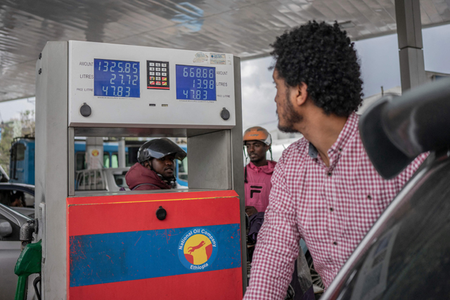 This photo shows a man looking at new fuel prices in Addis Ababa on Wednesday while the price of Brent oil has dropped slightly at the international level  (AFP photo)