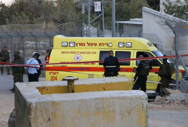 Israeli soldiers gather by an ambulance near a checkpoint of the Israeli illegal housing units of Kiryat Arba in the West Bank town of Hebron, on Monday (AFP photo)