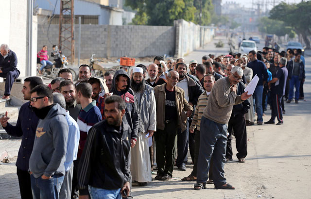 Palestinian Hamas-hired employees wait to receive their salaries, in the southern Gaza Strip, on Friday (Reuters photo)
