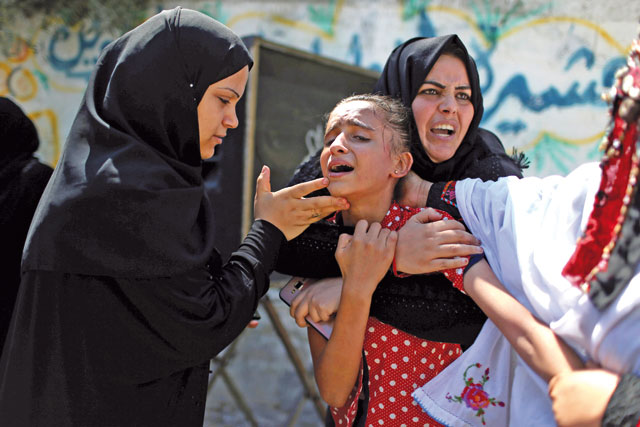 A relative of Palestinian teen Sohaib Abu Kashef, who died of wounds he sustained during a protest at the Israel-Gaza border fence, mourns during his funeral in Khan Younis in the southern Gaza Strip, on Sunday (Reuters photo)