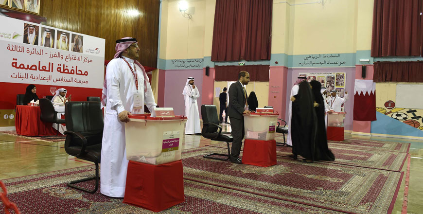 Bahraini election officials wait for voters during parliamentary election at a polling station in Manama on Saturday (AFP photo)