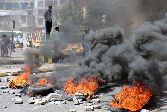 Protesters block a street with burning tyres after the Yemeni riyal has severely plunged against foreign currencies, in Aden, Yemen, on Sunday (Reuters photo)