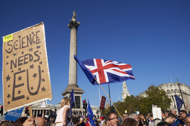 Demonstrators wave EU flags and hold up placards as they pass Trafalgar Square, taking part in a march calling for a People's Vote on the final Brexit deal, in central London, on Saturday  (AFP photo)