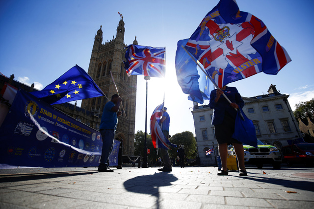 Anti-Brexit protestrs wave flags outside the Houses of Parliament in London, Britain, on Thursday (Reuters photo)