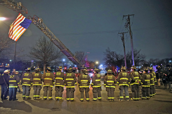 Chicago fire-fighters and police officers line up outside of the Cook County Medical Examiner's office waiting for the remains of Chicago Police officer Samuel Jimenez in Chicago, Illinois, on Tuesday (AFP photo)
