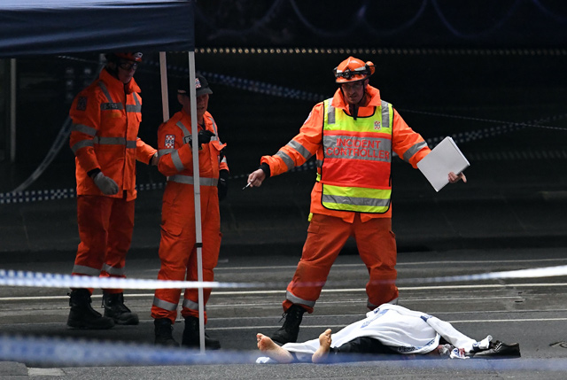 State Emergency Service personnel work at the crime scene as a body lies on the ground following a stabbing incident in Melbourne on Friday (AFP photo)