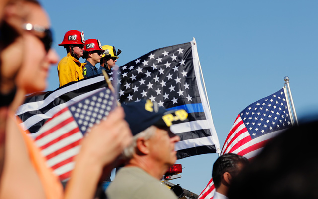 Los Angeles County firefighters watch from an overpass as a procession for the body of Sergeant Ron Helus, who died in a shooting incident at a Thousand Oaks bar, drives down Ventura HIghway 101, California, US, on Thursday (Reuters photo)