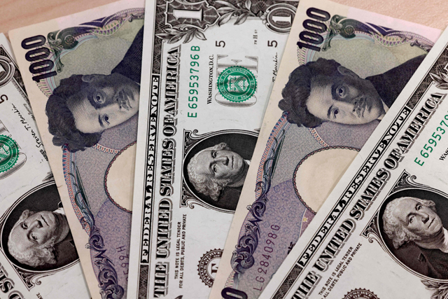 This photo illustration shows Japanese 1,000 yen and 1 US dollar banknotes in Tokyo, on Wednesday (AFP photo)