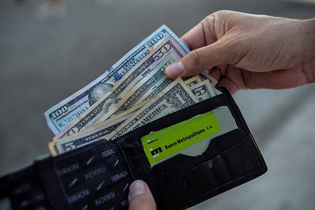  A man shows his wallet with US dollars in it in a street of Havana, on  September 15 (AFP photo)