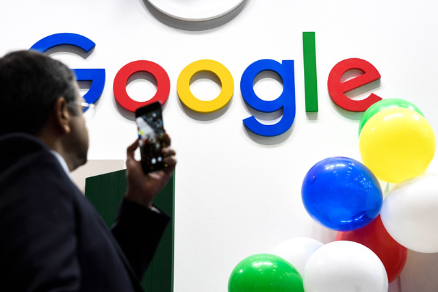 In this file photo taken on May 16, 2019 in Paris, a man takes a picture with his mobile phone of the logo of the US multinational technology and Internet-related services company Google as he visits the Vivatech startups and innovation fair (AFP photo)