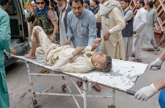 Volunteers carry an injured man on a stretcher to a hospital, following a bomb blast in Haska Mina district of Nangarhar Province, on Friday (AFP photo)