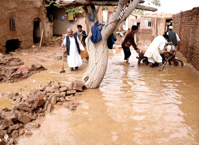 People salvage items from a house destroyed by flood in Enjil district of Herat province, Afghanistan, on Friday (Reuters photo)