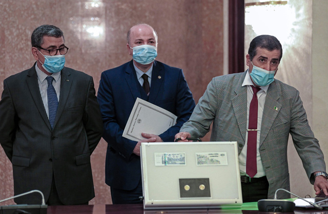 This photo, taken on July 4, shows Algerian Prime Minister Abdelaziz Djerad (left), Finance Minister Aymane Benabderrahmane (centre) and Governor of Bank of Algeria (Central Bank) Rosthom Fadli presenting samples of new banknotes and a coin commemorating resistance fighters against France’s colonial occupation of the country, during a ceremony in Algiers, a day ahead of the 58th anniversary of Algeria’s independence (AFP photo)