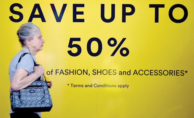 A pedestrian passes a store with a sale in Sydney on Tuesday (AFP photo)