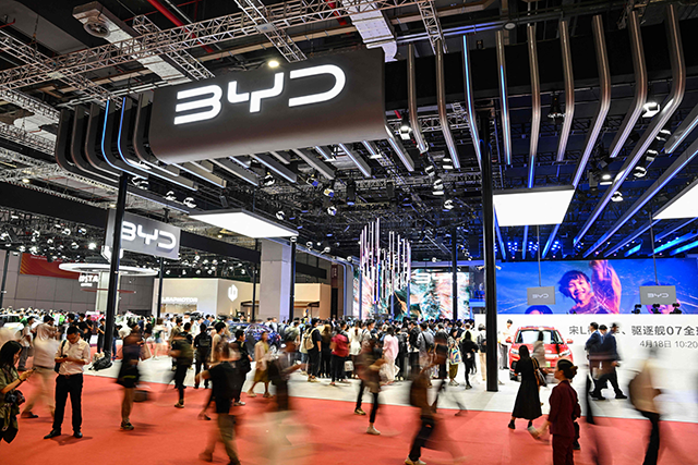 The file photo taken on April 18, 2023, shows people walking next to a BYD stand during the 20th Shanghai International Automobile Industry Exhibition in Shanghai (AFP photo)