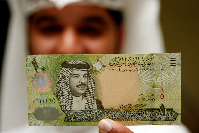 A Central Bank of Bahrain official shows a new Bahraini 10 dinars banknote on the first day of its release in Bahraini capital of Manama on March 17, 2008 (Reuters file photo)