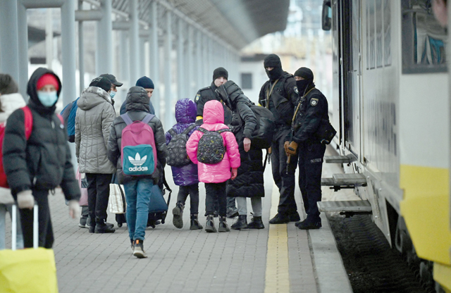 Parents accompany children and teenagers as they board a train after leaving Kyiv’s Central Children’s Hospital following its evacuation in Kyiv, on Monday, 12 days after Russia launched its military invasion of Ukraine (AFP photo by Sergei Supinsky)