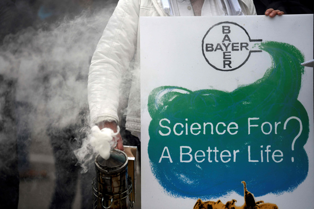 In this photo taken on April 26, a protester stands with a bee smoker and a placard reading ‘Science for a better life?’ during a demonstration outside the World Conference Centre where the annual general meeting of German chemicals giant Bayer takes place in Bonn, western Germany (AFP file photo)
