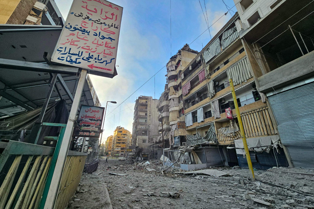 Debris are scattered in a street in front of damaged buildings, in the aftermath of Israeli airstrikes that targeted the neighbourhood of Haret Hreik in Beirut's southern suburbs, on Saturday, as the war between Israel and Hizbollah continues (AFP photo)