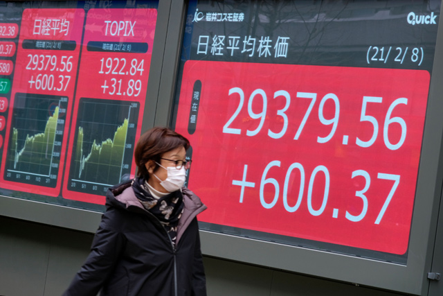 A pedestrian walks past an electronic quotation board displaying share prices on the Tokyo Stock Exchange in Tokyo on Monday (AFP photo)