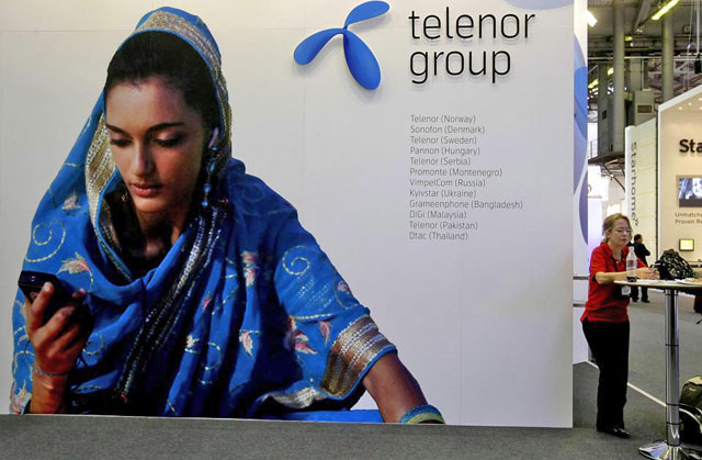 A visitor rests under a Telenor Group sign at the GSMA Mobile World Conference in Barcelona, Spain (Reuters file photo)