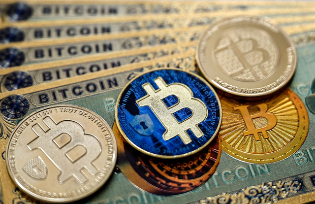 This illustration photograph taken on November 22, 2024 in Istanbul shows physical banknotes and coin imitations of the Bitcoin cryptocurrency (AFP photo) t