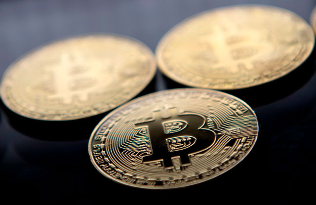 This photo taken last Monday shows gold plated souvenir Bitcoin coins arranged for a photograph in London (AFP photo)