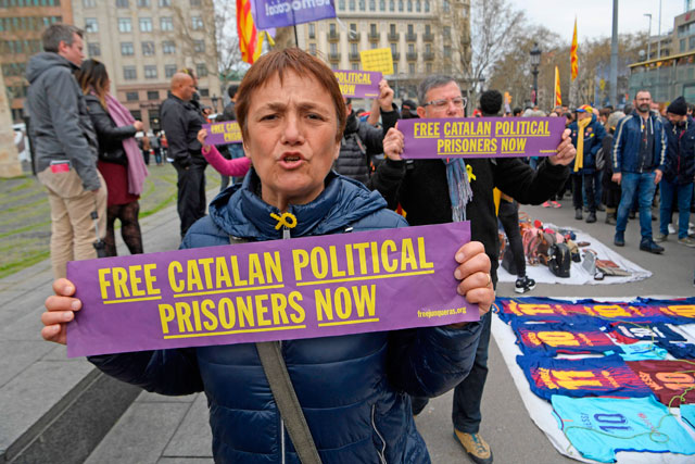 Protesters shout slogans while holding signs calling for the release of jailed Catalan separatists during a demonstration in Barcelona on Sunday after German police arrested Catalonia’s former president (AFP photo)