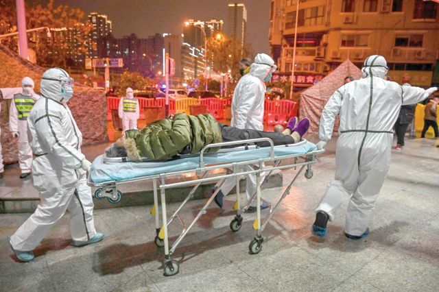 Medical staff members, wearing protective clothing to help stop the spread of a deadly virus which began in the city, arrive with a patient at the Wuhan Red Cross Hospital in Wuhan, on Saturday (AFP photo)