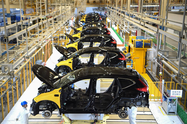 This photo, taken on Wednesday, shows employees working on an assembly line at the third auto plant of Dongfeng Honda in Wuhan in China’s central Hubei province (AFP photo) 