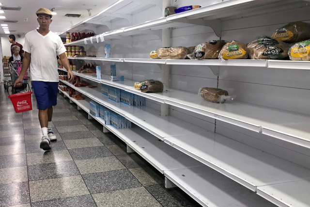 People walk looking for products at a supermarket in Caracas, Venezuela, on Saturday (Reuters photo)