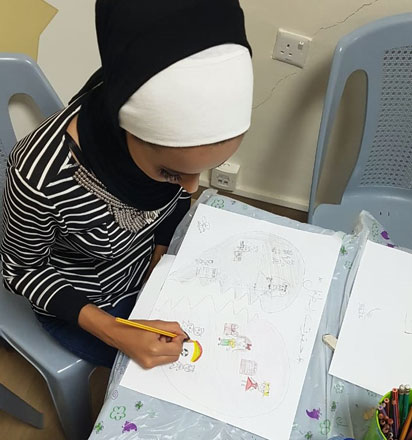 Aziza Abu Ayash shows off her cartooning skills at a workshop in Amman (Photo courtesy of UNESCO)
