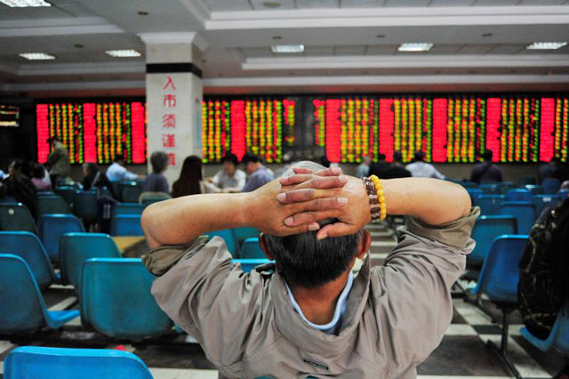 An investor looks at an electronic board showing stock information at a brokerage house in Nanjing, China, on May 24 (Reuters file photo)