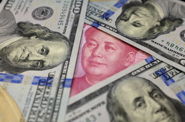 Benjamin Franklin US $100 banknotes and a Chinese 100 yuan banknote with the late Chinese Chairman Mao Zedong are seen in this January 21, 2016 picture illustration (Reuters photo)