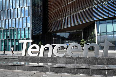 This photo taken on July 10, 2022 shows people walking past the Tencent headquarters in Shenzhen in China's southern Guangdong province (AFP photo)