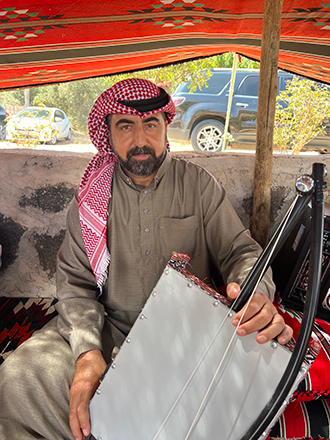 Ziad Masry, a musician showcasing the Rababa, a traditional stringed instrument (Photo by Sophie Constantin)