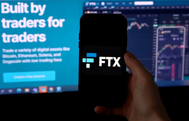 In this file photo illustration taken on February 9, 2022, shows a smart phone screen displaying the logo of FTX, the crypto exchange platform, with a screen showing the FTX website in Arlington, Virginia (AFP photo)