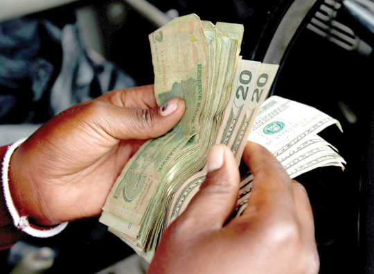 An illegal money changer counts dollar notes in Harare, Zimbabwe, on Thursday (Reuters photo)