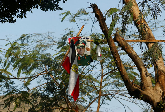 A poster of Egyptian President Abdel Fattah Al Sisi which reads ‘We will die and Egypt will live’ and the national flag are seen on a tree at the centre of downtown Cairo, Egypt, on Monday (Reuters photo)