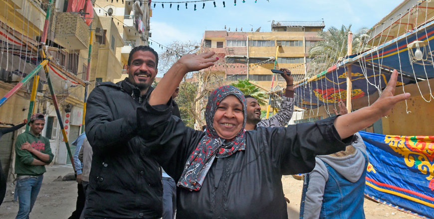 Egyptians dance and celebrate outside a polling station in Imbaba neighbourhood in the capital Cairo's southwestern Giza district on the first day of the 2018 presidential elections on Monday (AFP photo)