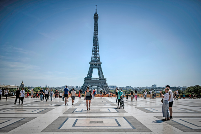   Tourists visit the Esplanade des Droits de l’Homme with the Eiffel tower in the background, in Paris, on August 6 (AFP file photo)