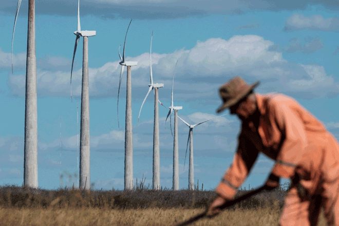 In this file photo taken on June 30, 2016, a farmer works near wind turbines at Vamcruz Windfarm, developed by three energy companies including French renewable energy power plants operator Voltalia Group in Serra do Mel, Rio Grande do Norte State, Brazil (AFP photo)