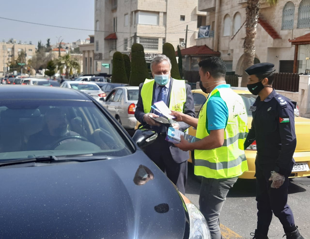 Environment Minister Nabil Masarweh joins the ministry’s team in distributing car trash bags to motorists on Tuesday as part of the  ‘Keep your bag in your car’ initiative (Petra photo)