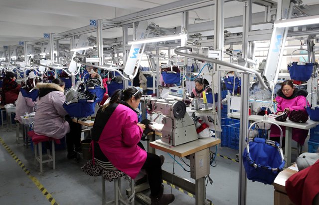 This photo taken on Saturday shows workers making caps for export in a textile workshop in Lianyungang, in China's eastern Jiangsu province (AFP photo)
