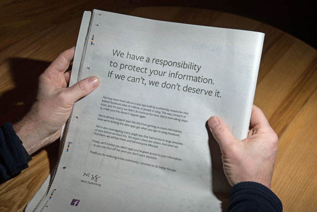A man reads a full-page advertisment, taken out by Mark Zuckerberg, the chairman and chief executive officer of Facebook to apologise for the large-scale leak of personal data from the social network, on the backpage of a newspaper, in Ripon, England, on Sunday (AFP photo)