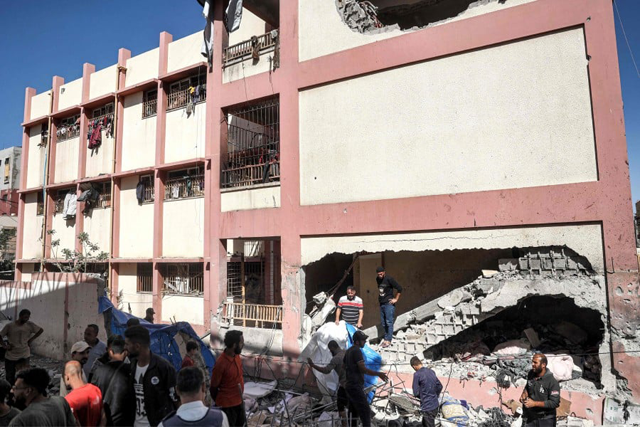 People inspect destruction in the Shuhada (Martyrs) school, which was hit by Israeli bombardment, in Nuseirat in the central Gaza Strip (AFP photo)