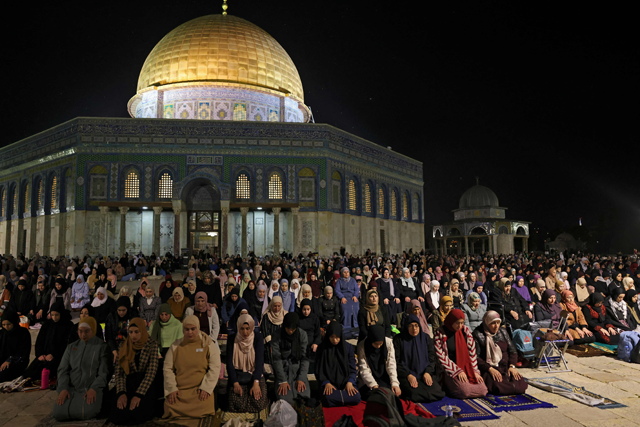 Palestinian Muslim devotees perform an evening prayer known as 'Tarawih' outside the Dome of the Rock in Jerusalem's  Al Aqsa Mosque compound during the holy fasting month of Ramadan, on Saturday (AFP photo)